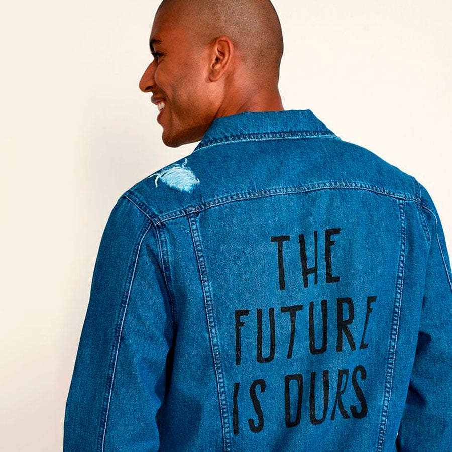 Modelo vestindo jaqueta jeans com a frase "The Future is Ours" nas costas, um exemplo de roupa reciclável da C&A.